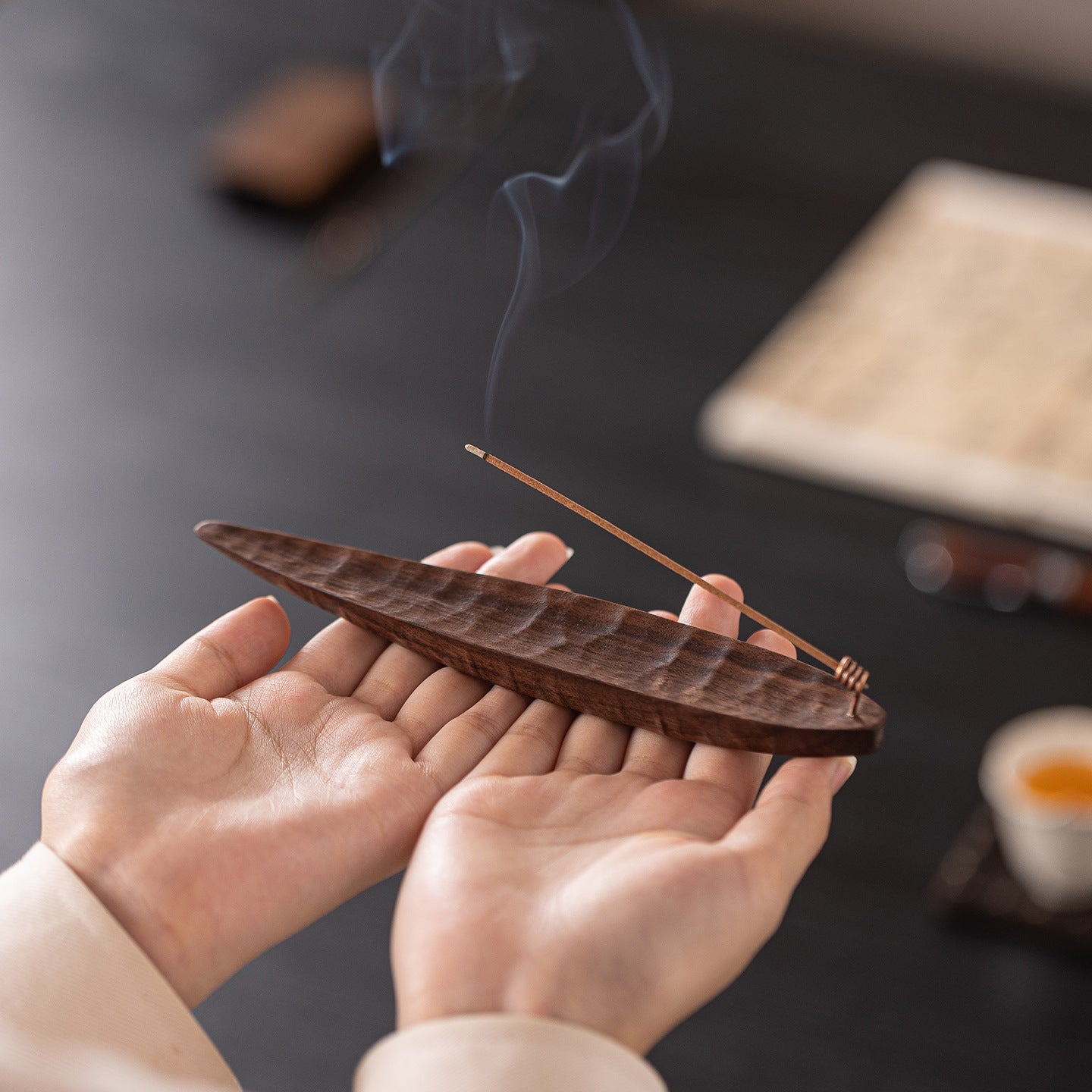 Handcrafted black walnut incense holder with a burning incense stick, designed for meditation, yoga, and home relaxation.