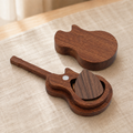 Open black walnut guitar pick case showing the carved storage compartment and magnetic lid for securely organizing guitar picks.