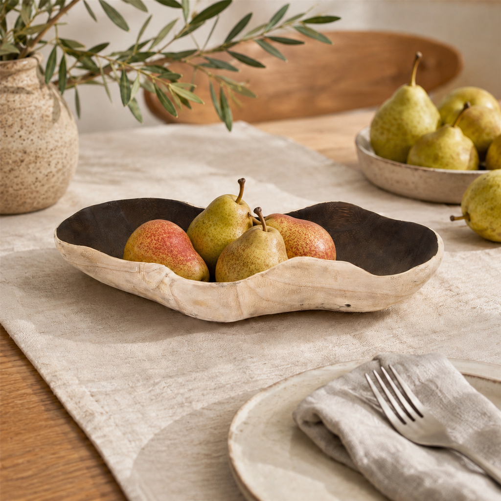 Empty handcrafted paulownia wood fruit tray featuring an irregular freeform silhouette and a naturally carved wood surface.
