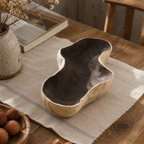Handcrafted paulownia wood fruit tray displayed on a wooden table in a warm, natural home setting with a calm rustic aesthetic.