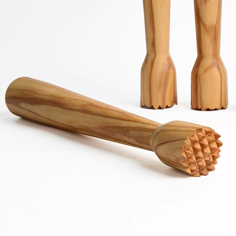 Close-up of a handcrafted olive wood lemon squeezer with natural wood grain and textured crushing head.
