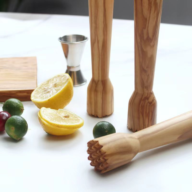 Olive wood lemon squeezer and ice crusher beside a refreshing citrus drink, perfect for cocktails and summer beverages.