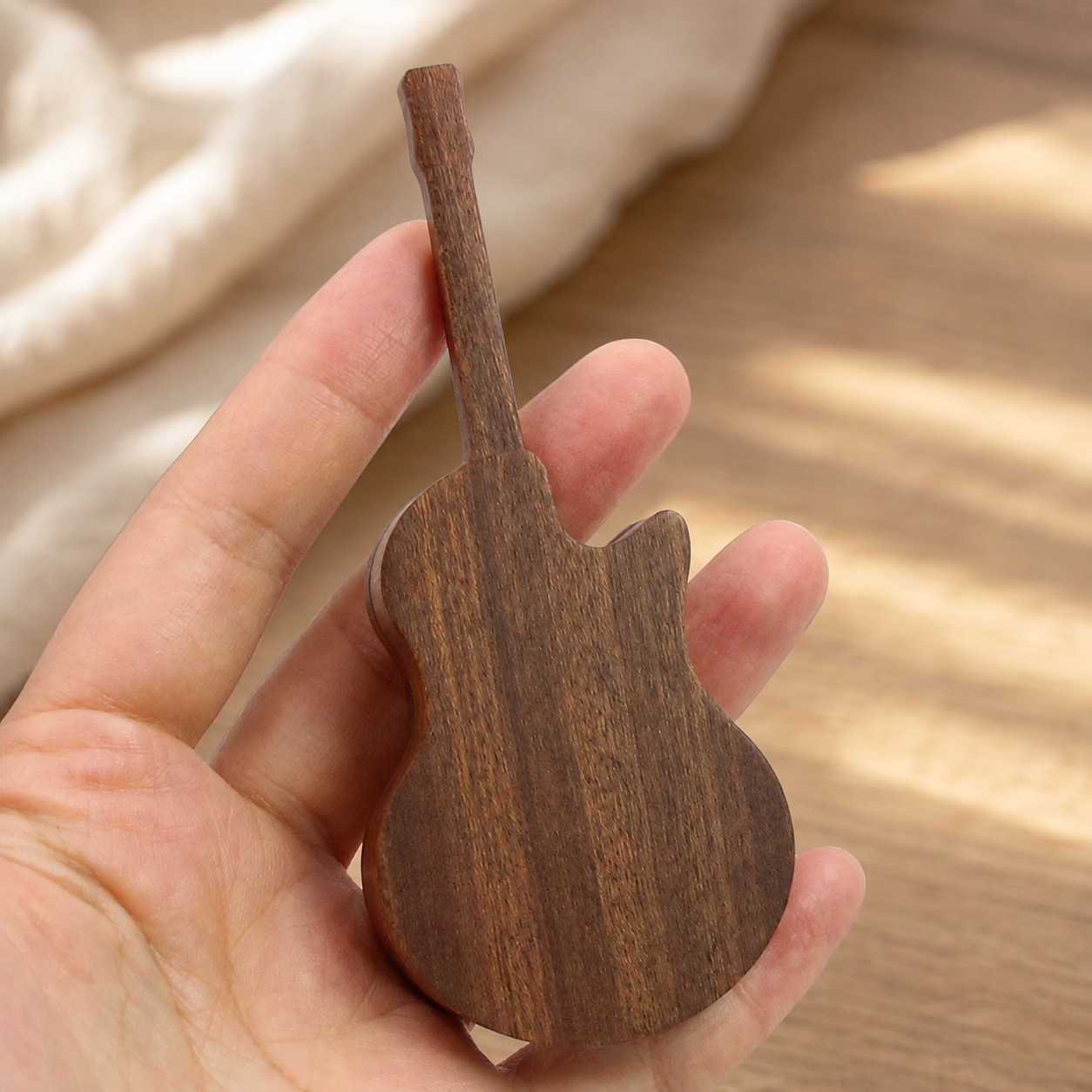 Close-up of the handcrafted black walnut guitar pick case highlighting the natural wood grain, smooth finish, and precision craftsmanship.