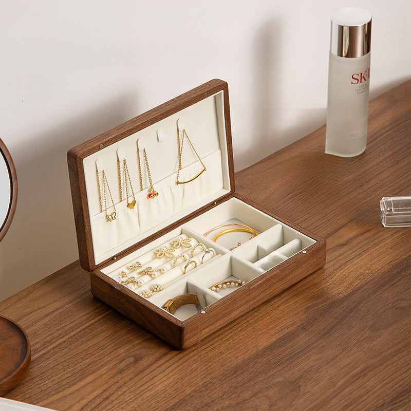 Open black walnut jewelry box with velvet-lined compartments for organizing rings, necklaces, earrings, and bracelets.