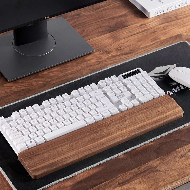 Close-up of handcrafted black walnut keyboard wrist rest showing smooth edges and natural wood grain.
