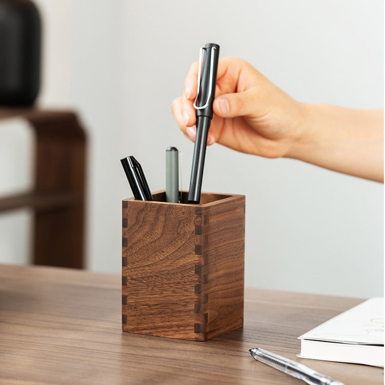 Solid black walnut pen holder showcasing natural wood grain and handcrafted joinery.
