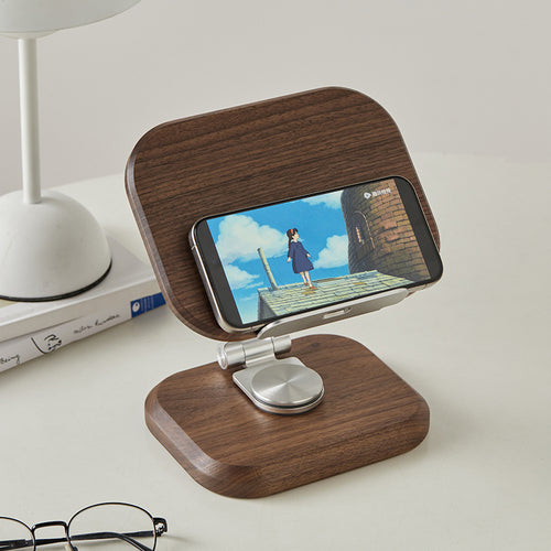 Handcrafted personalized black walnut phone and tablet stand holding a smartphone for hands-free viewing.