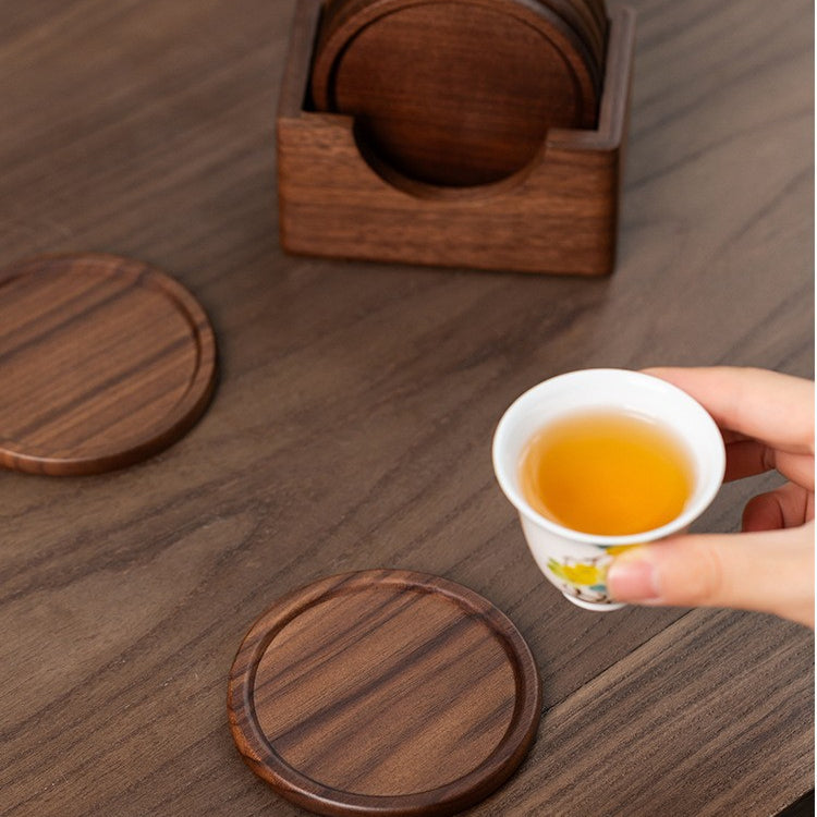 Handcrafted black walnut wood coasters protecting a tabletop from hot coffee and cold drinks.