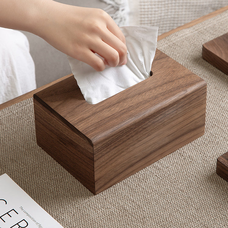 Solid black walnut wood tissue box cover displayed in a warm living room with modern minimalist decor.