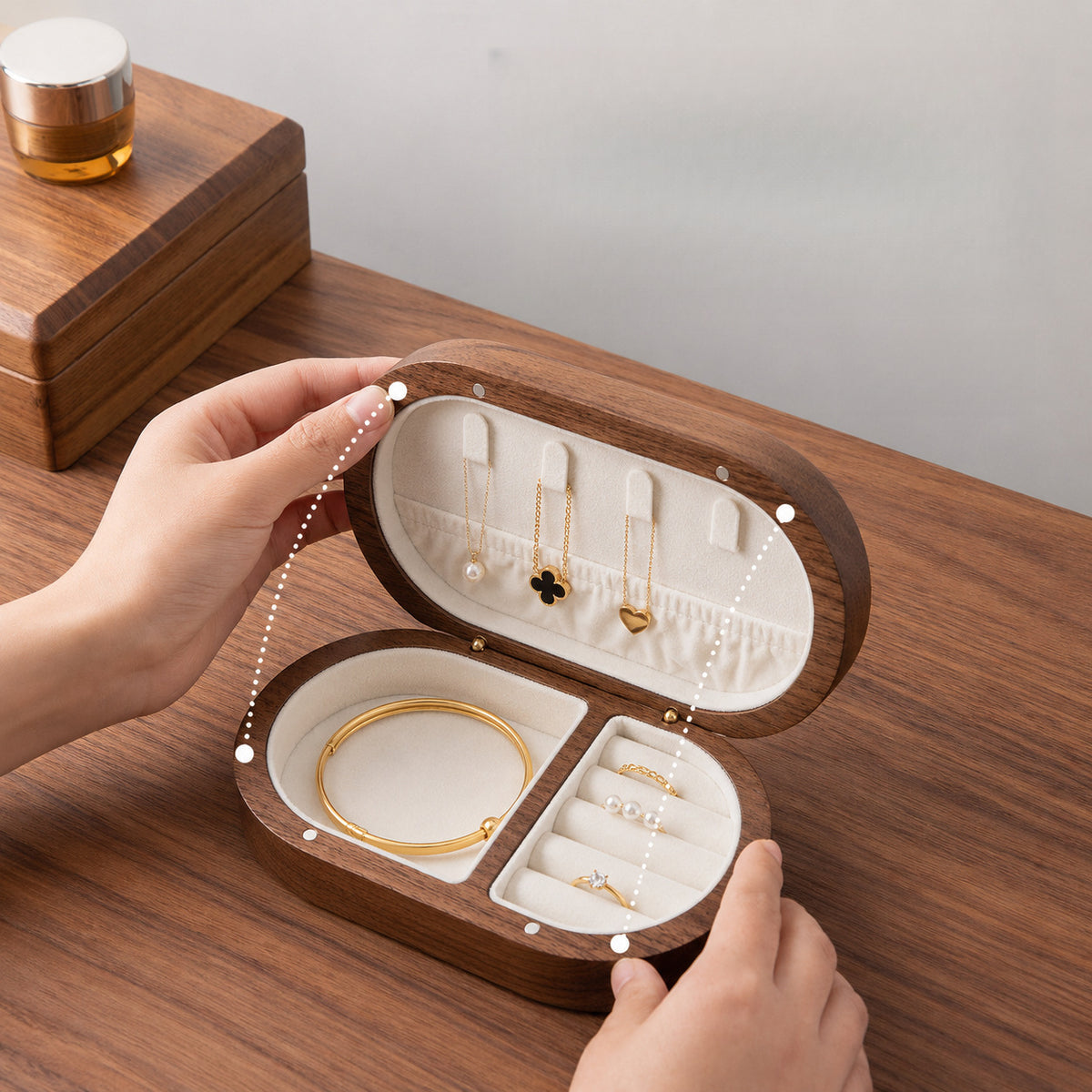 Handcrafted black walnut wood travel jewelry box displayed on a wooden vanity in a warm minimalist setting.