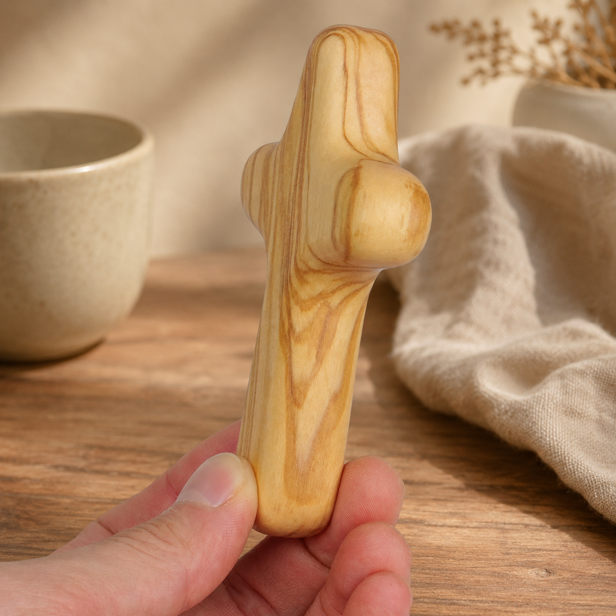 Olive wood comfort cross held comfortably in the hand, offering a calming reminder of faith, hope, and encouragement during prayer or meditation.