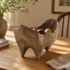 Handcrafted rustic wooden fruit bowl displayed on a dining table with fresh fruit, highlighting its organic shape and natural character.