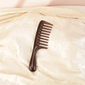 Solid wood hair comb placed in soft natural light lifestyle scene