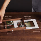 Wooden photo frame placed beside dried flowers in soft light