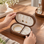 Black walnut travel jewelry box with necklace hooks, ring slots, and divided compartments for compact jewelry storage.