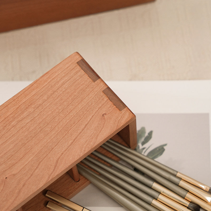 Cherry wood makeup organizer box styled on a warm vanity table with beauty accessories.