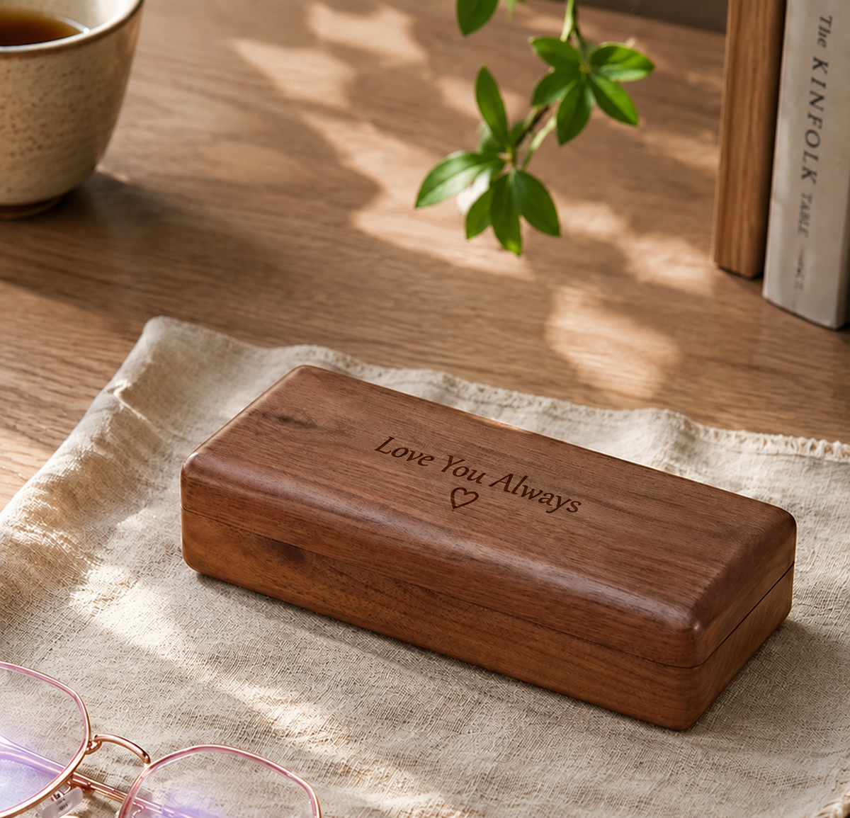 Personalized black walnut glasses case with engraved text and a smooth wooden lid for storing eyeglasses.